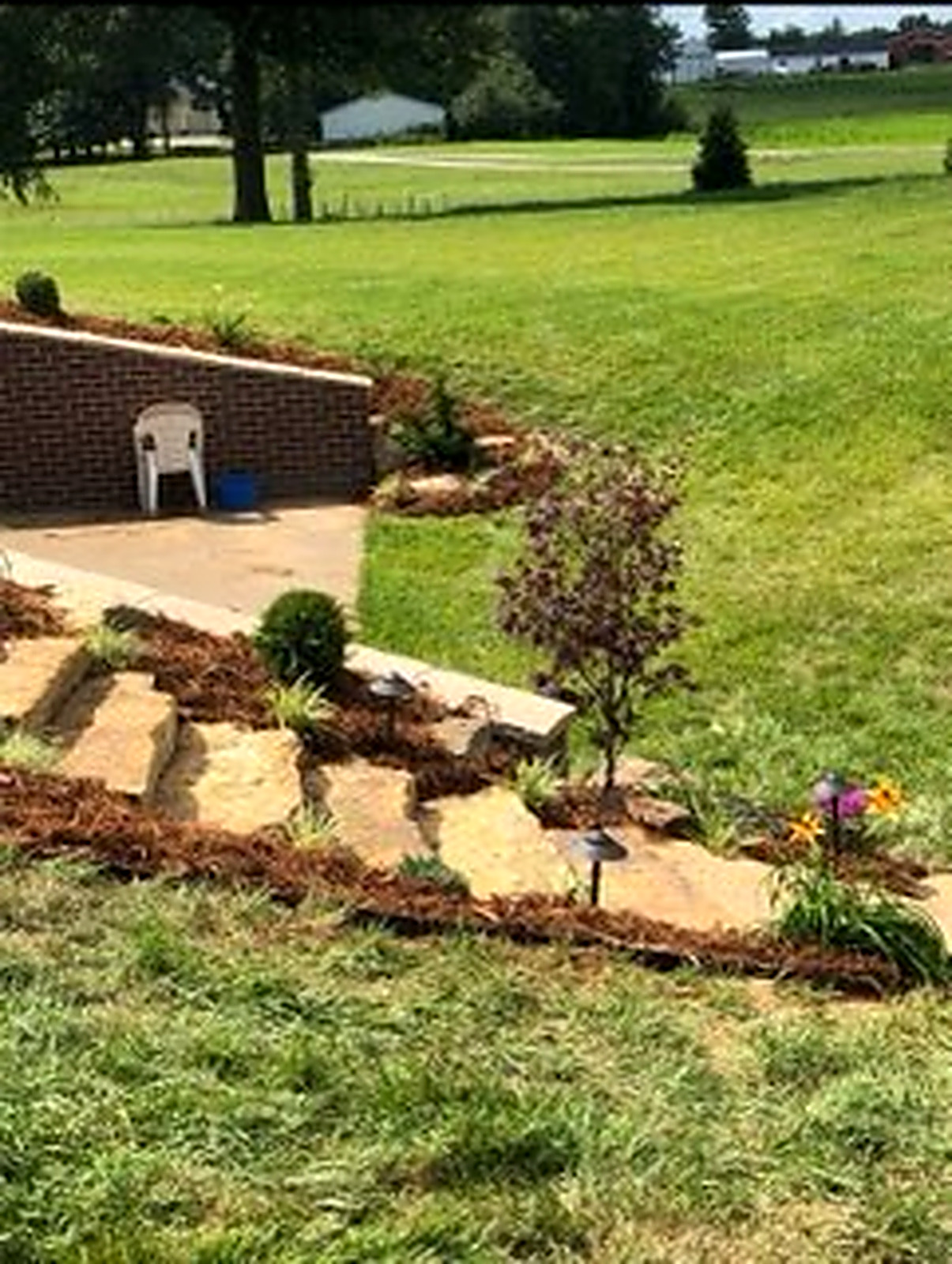 Backyard patio with stone steps and reshaped grade