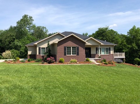 Brick home with fresh mulched foundation beds and a manicured lawn