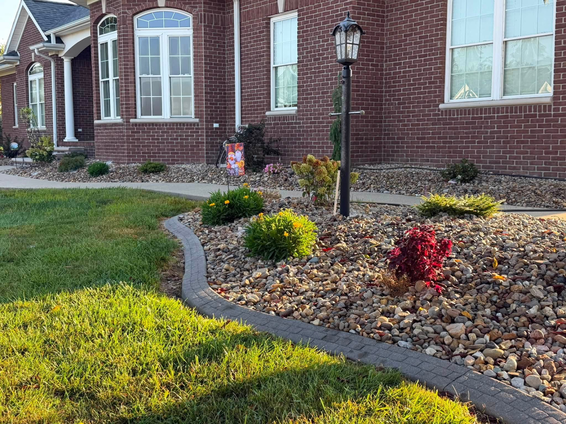 Brick home with a curved decorative rock garden and landscape edging