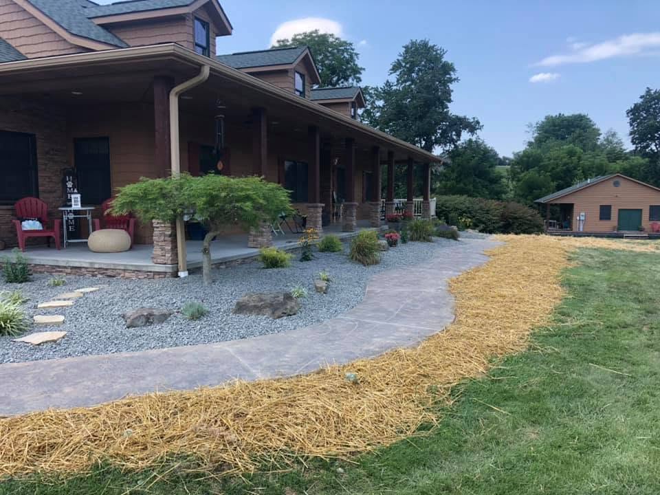Country home with a stamped walkway, decorative gravel and new plantings