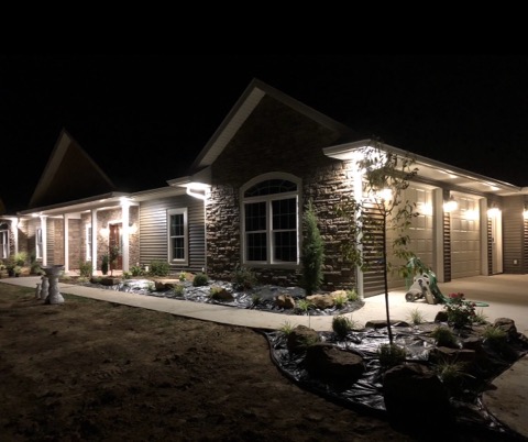 Evening landscape lighting along a new rock bed and walkway