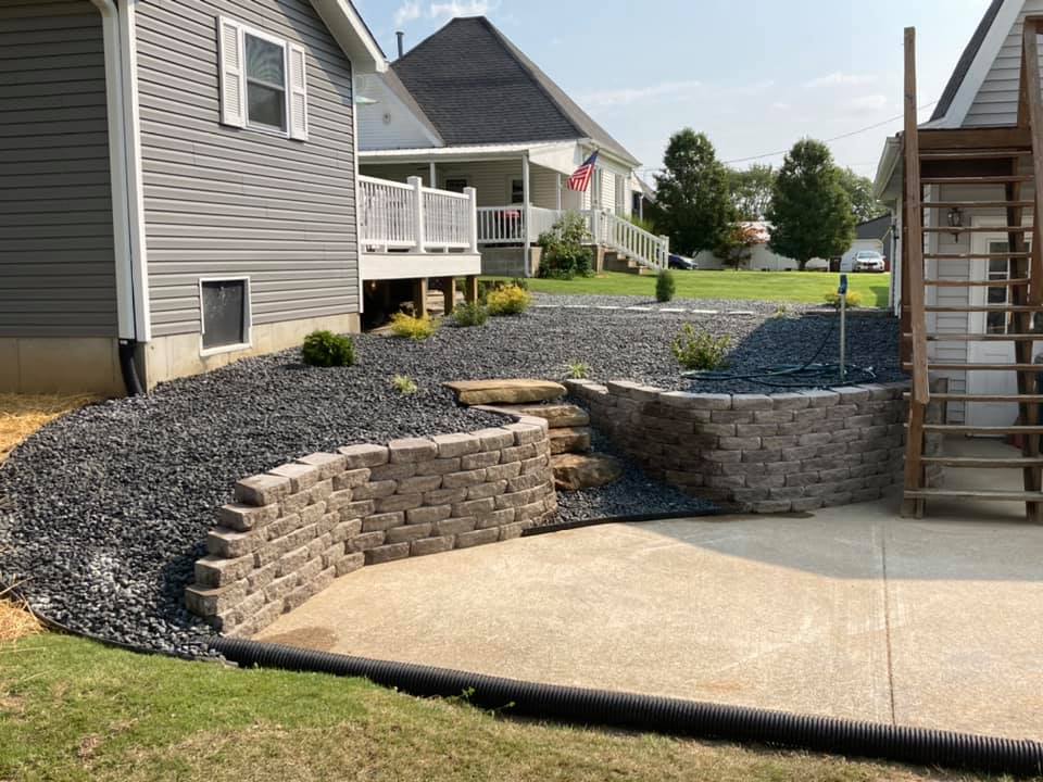Natural stone retaining wall with layered plantings
